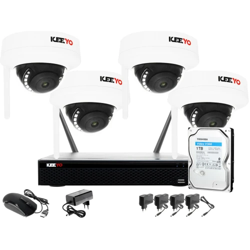Na zdjęciu znajduje się bezprzewodowy system monitoringu składający się z czterech kamer kopułkowych, rejestratora, dysku twardego Toshiba 1TB oraz akcesoriów takich jak myszka i zasilacze. Kamery i rejestrator są oznaczone logo "KEEYO".
