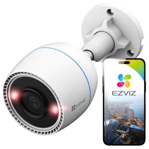 Biała, cylindryczna kamera bezprzewodowa EZVIZ z widocznym obiektywem i diodami LED, zamontowana na ścianie. Obok kamery znajduje się smartfon z aplikacją EZVIZ, pokazującą widok z kamery na panoramę miasta.