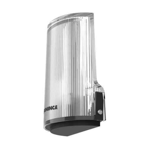 Na zdjęciu znajduje się nowoczesna lampa Beninca Star LED o przezroczystej, żebrowanej obudowie. Lampa ma czarną podstawę i jest przeznaczona do montażu na ścianie.