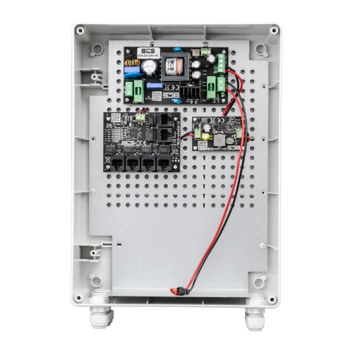 Zdjęcie przedstawia wnętrze switcha PoE BCS UPS IP4, ukazujące jego komponenty elektroniczne zamontowane na perforowanej płycie. Obudowa jest prostokątna, wykonana z jasnego tworzywa sztucznego, z widocznymi złączami i okablowaniem.